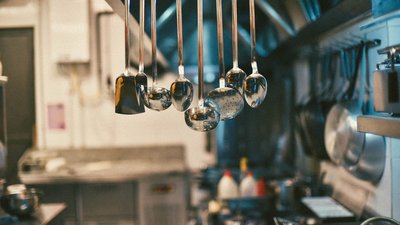 Photo d’illustration — ustensiles suspendus dans une cuisine professionnelle
