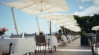 Photo d’illustration — terrasse de restaurant avec tables dressées et parasols
